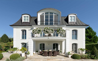 Klassisches Wohnhaus mit großen Fenstern und verglasten Terrassentüren