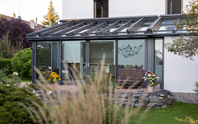 Verglaster Wintergarten mit Aluminiumprofilen als geschützter Platz am Haus