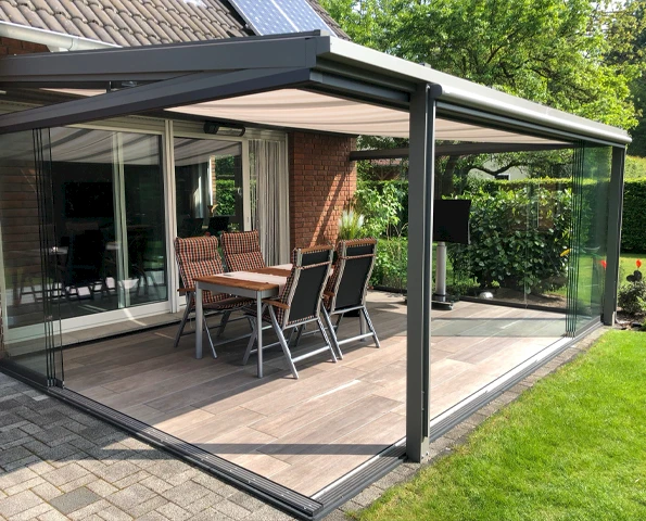 Sommergarten mit Glas-Schiebeelementen und Sonnenschutz an einem Einfamilienhaus
