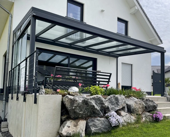 Moderne Terrassenüberdachung aus Aluminium und Glas an einem Einfamilienhaus