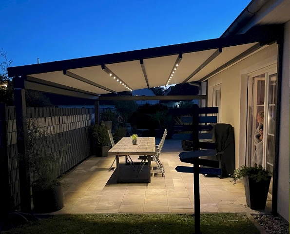 Terrassenüberdachung mit textilem Sonnenschutz und integrierter LED-Beleuchtung