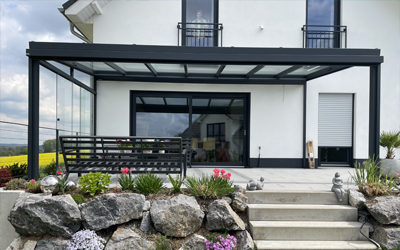 Terrassenüberdachung mit textilem Sonnenschutz und großzügigem Sitzbereich